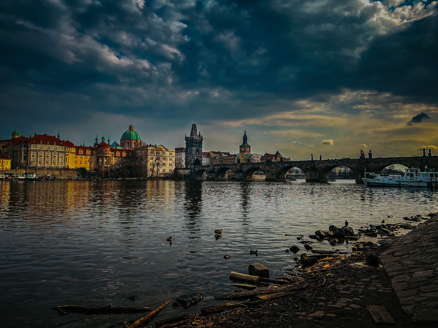 Charles Bridge crossing the Vltava in Prague under a clouded sky